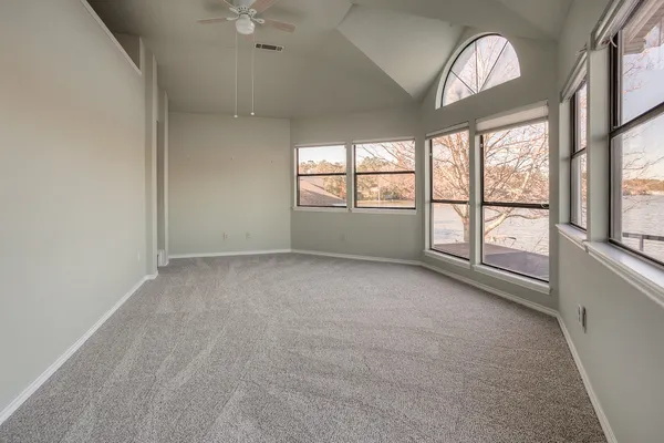 an empty room with a fireplace and windows