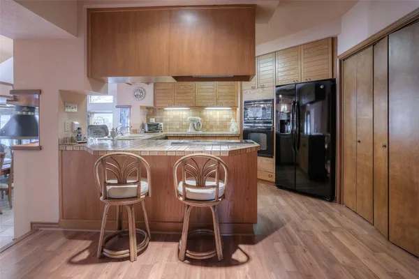 a kitchen with granite countertop a refrigerator cabinets and wooden floor