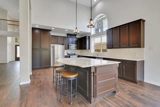 a kitchen with kitchen island a sink stove and refrigerator