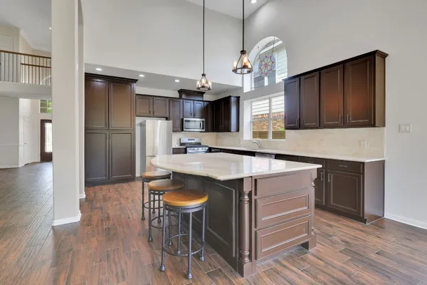 a kitchen with kitchen island granite countertop a sink stove and refrigerator