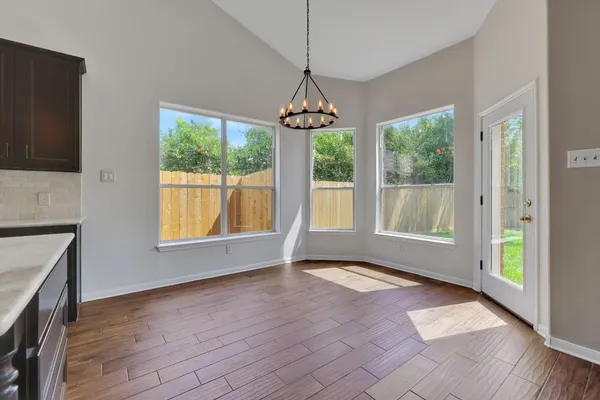 a view of an empty room with glass door and windows