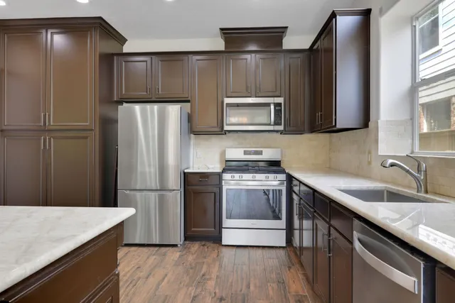 a kitchen with granite countertop a refrigerator and a sink