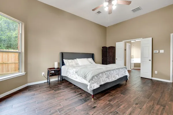 a bedroom with a bed and wooden floor