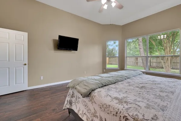 a bed sitting in a spacious bedroom next to a window