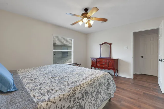 a bedroom with a large bed chandelier and a window