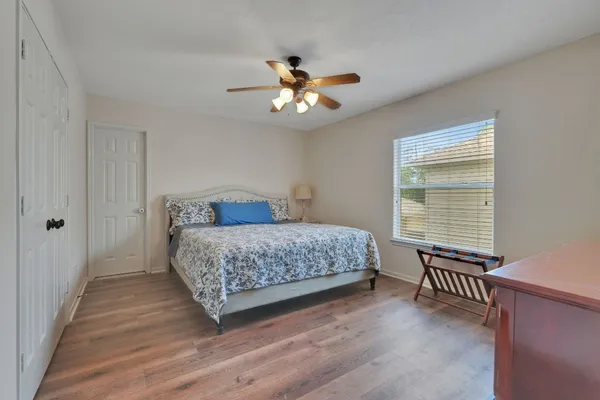 a bedroom with a large bed chandelier and a window
