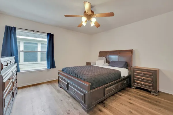 a spacious bedroom with a bed and a chandelier