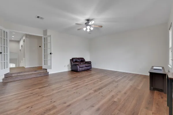 a view of empty room with wooden floor