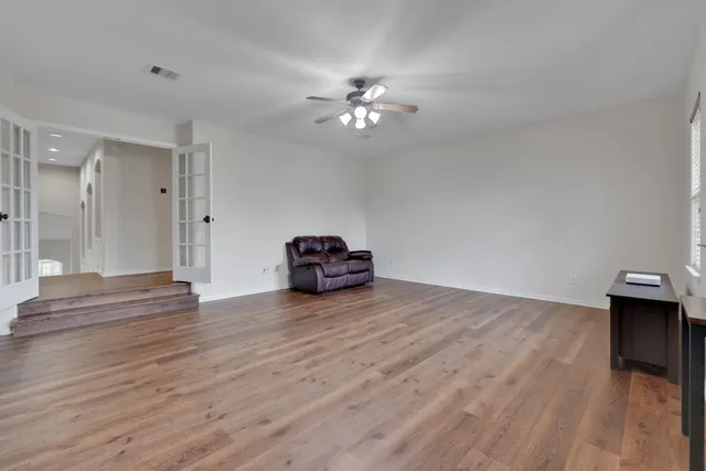 a view of empty room with wooden floor
