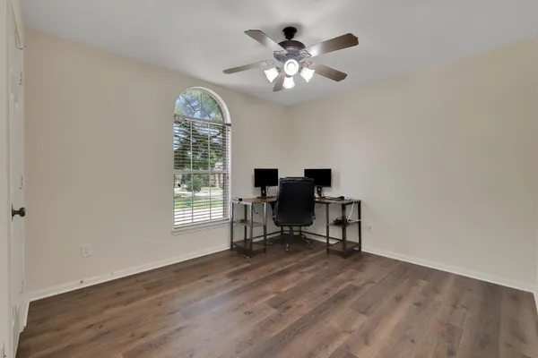 a view of a workspace with wooden floor and a window