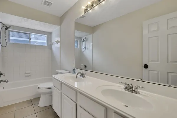 a bathroom with a double vanity sink toilet and a bathtub