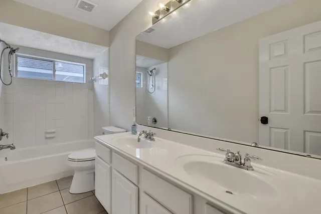 a bathroom with a double vanity sink toilet and a bathtub
