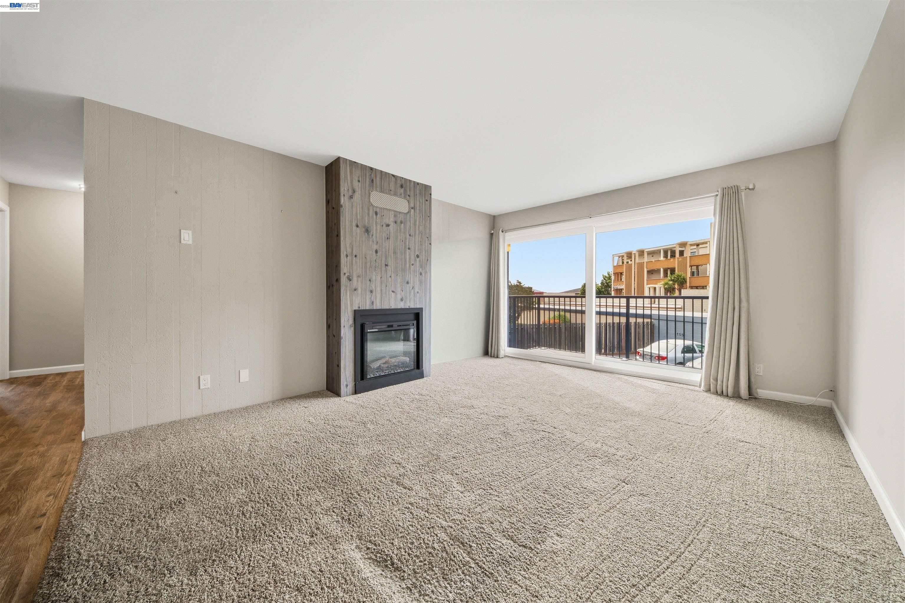 960 Shorepoint Court, Unit 116 Alameda, CA 94501 - Photo 2 of 20 a view of an empty room with a fireplace and a window