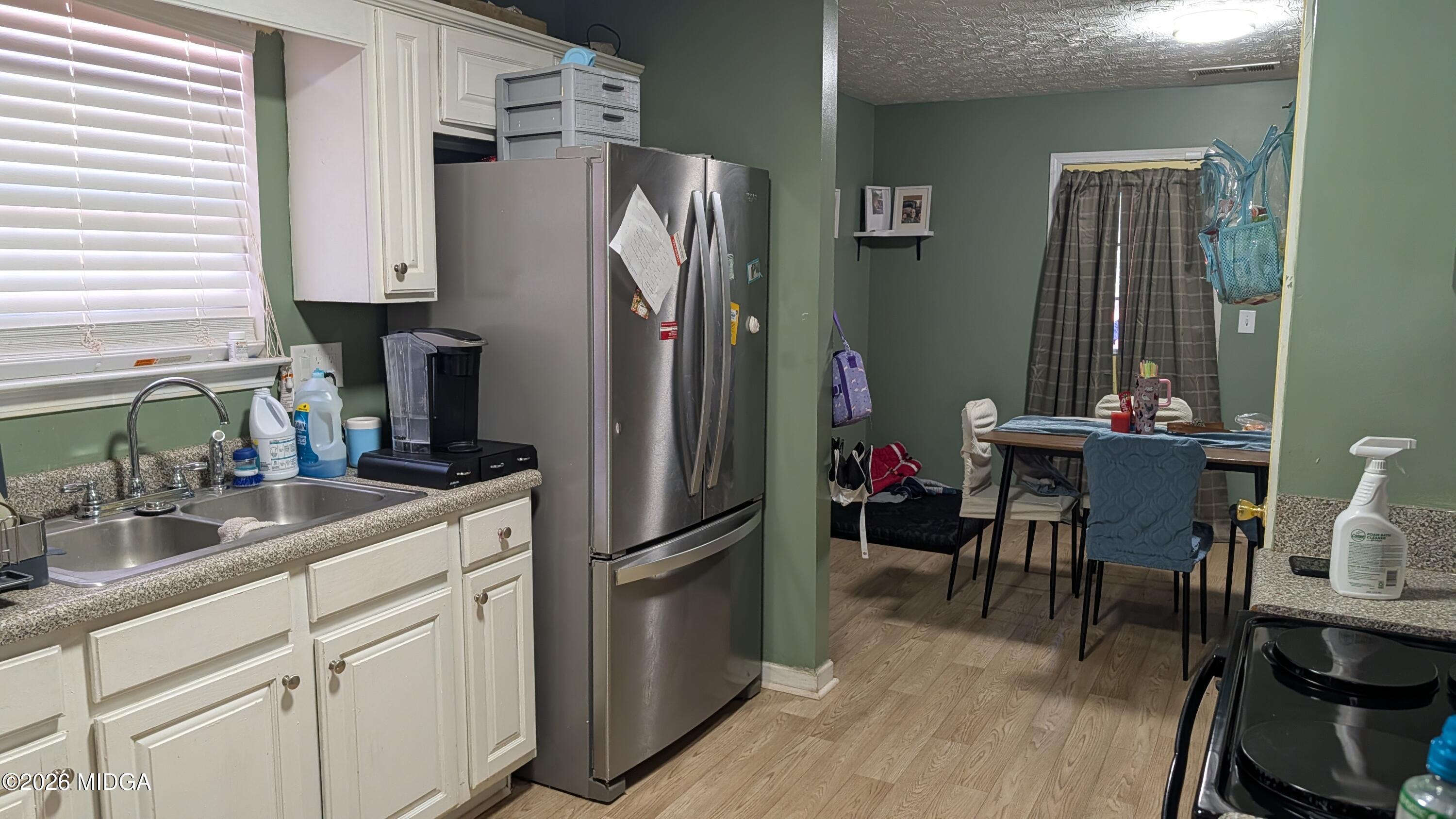 167 Apple Valley Road Macon, GA 31217 - Photo 6 of 22 a kitchen with stainless steel appliances a refrigerator a sink a stove and white cabinets