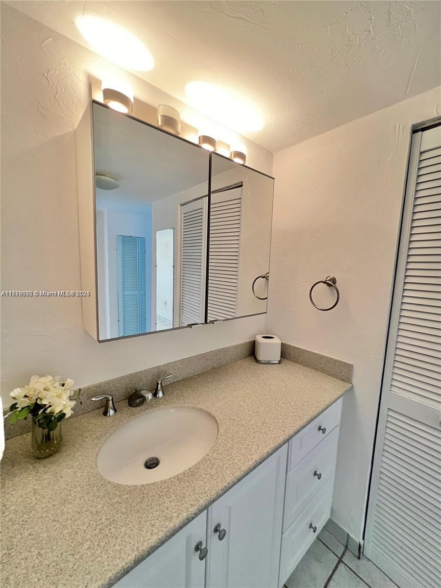 9273 Collins Avenue, Unit 801 Surfside, FL 33154 - Photo 12 of 15 a bathroom with a sink and a mirror