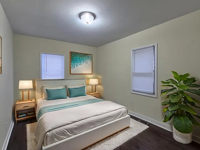 a bedroom with a bed and a potted plant