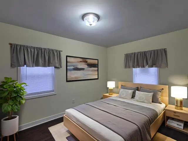 a bedroom with a bed and a potted plant