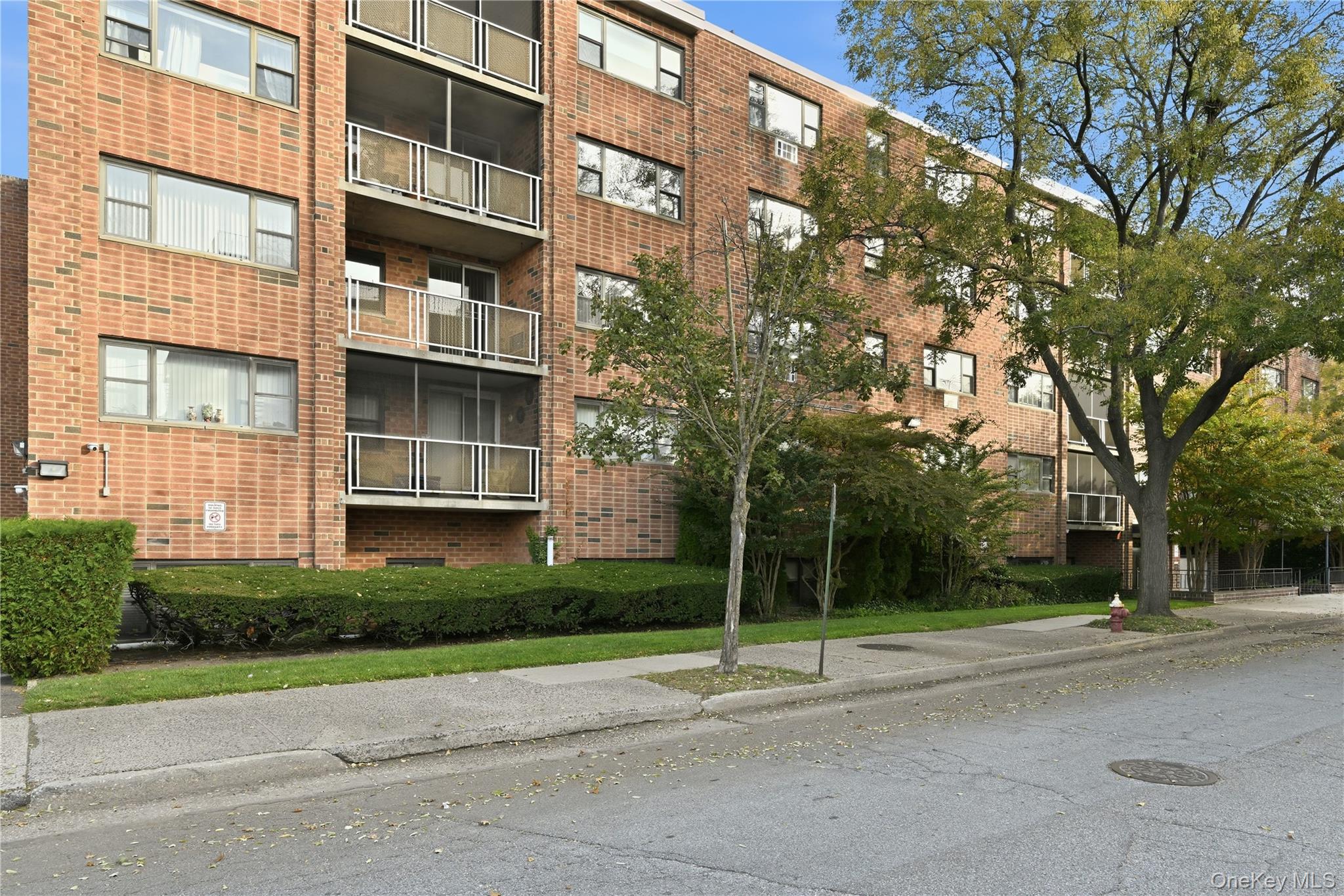 100 Clinton Avenue, Unit 2J Mineola, NY 11501 - Photo 20 of 24 a view of a tall building next to a road