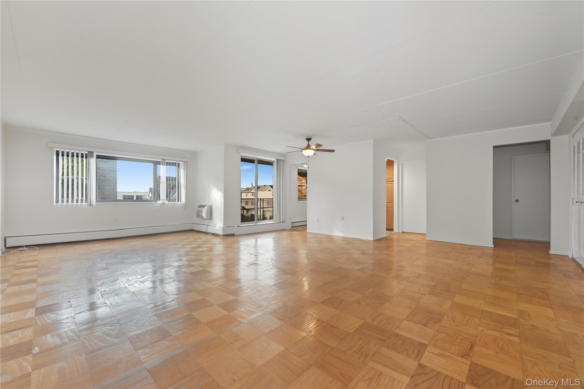 100 Clinton Avenue, Unit 2J Mineola, NY 11501 - Photo 2 of 24 a view of empty room with wooden floor and fan