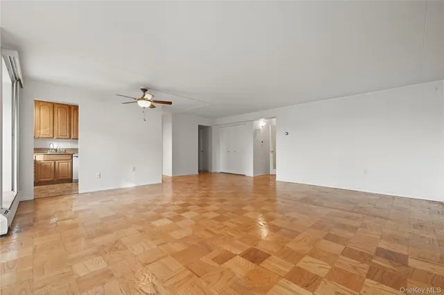 a view of an empty room with closet and a window