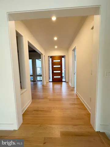 a view of a hallway with wooden floor and furniture