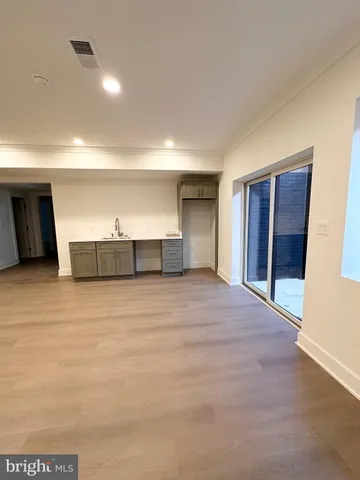 a view of empty room with wooden floor