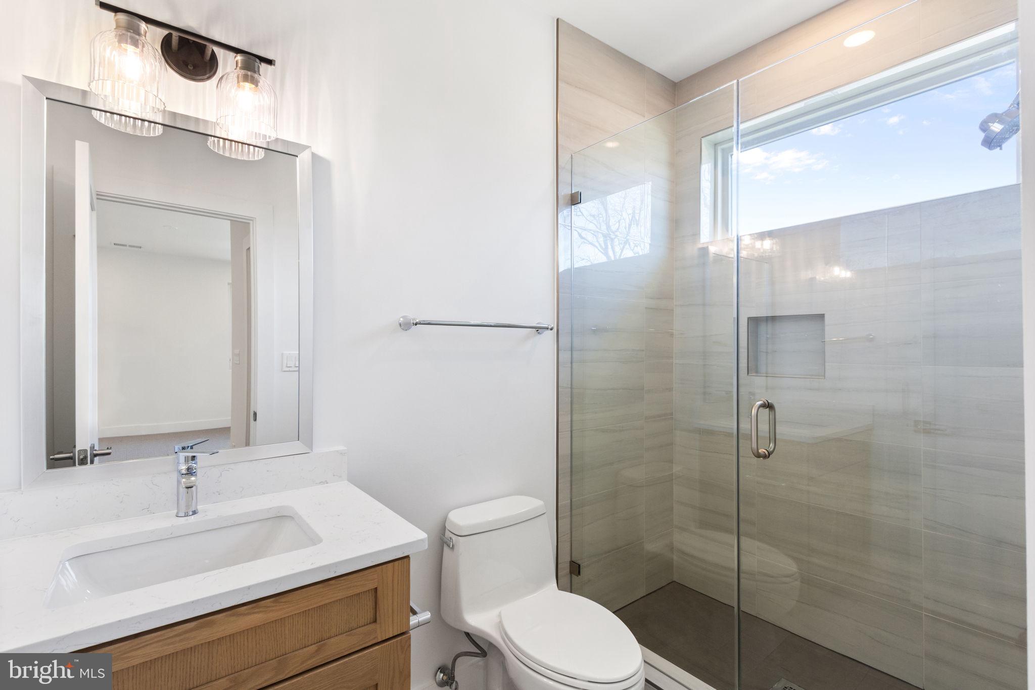 4017 Woodland Road Annandale, VA 22003 - Photo 58 of 76 a bathroom with a sink toilet a mirror and shower