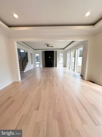 a view of a big room with wooden floor and windows