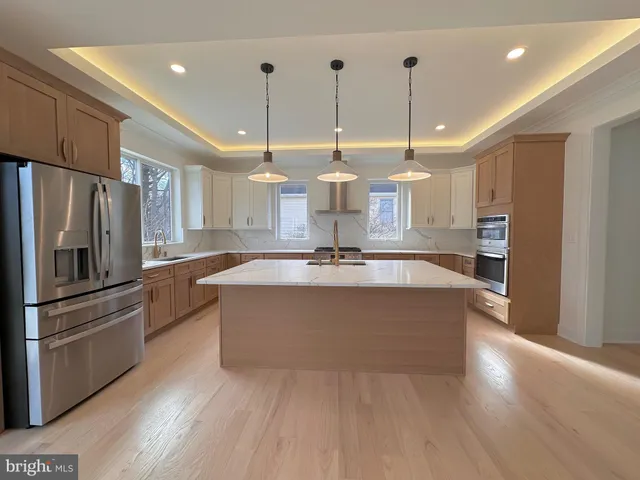 a large kitchen with stainless steel appliances granite countertop a refrigerator a oven and a large island