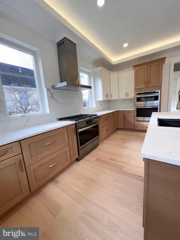 a kitchen with stainless steel appliances granite countertop a stove a sink and a microwave