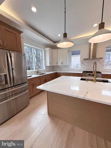 a kitchen with stainless steel appliances granite countertop a sink a stove and a refrigerator