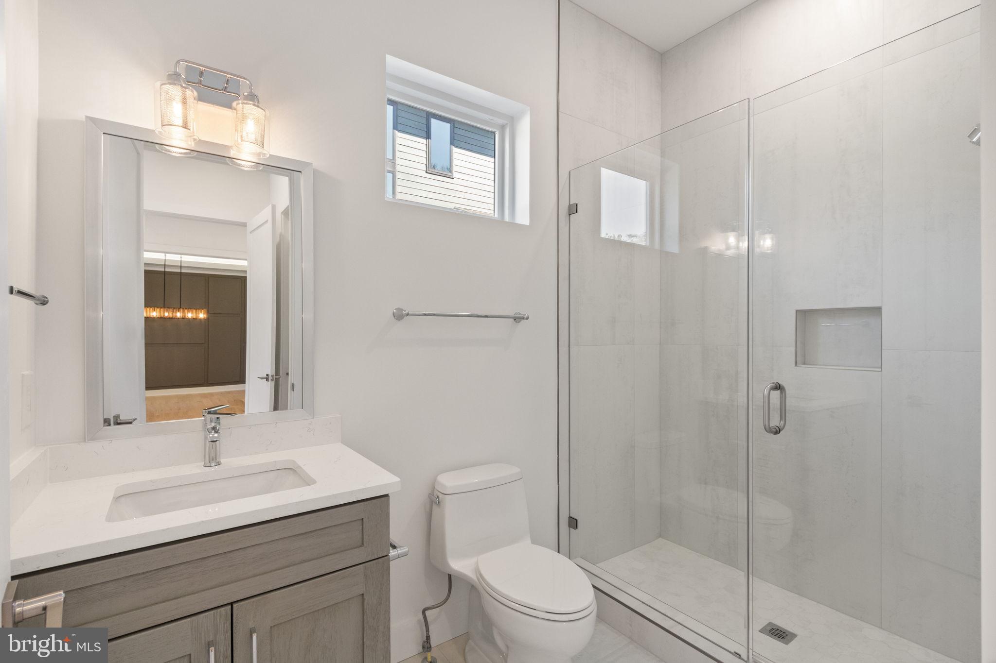 4017 Woodland Road Annandale, VA 22003 - Photo 10 of 76 a bathroom with a sink toilet vanity and shower