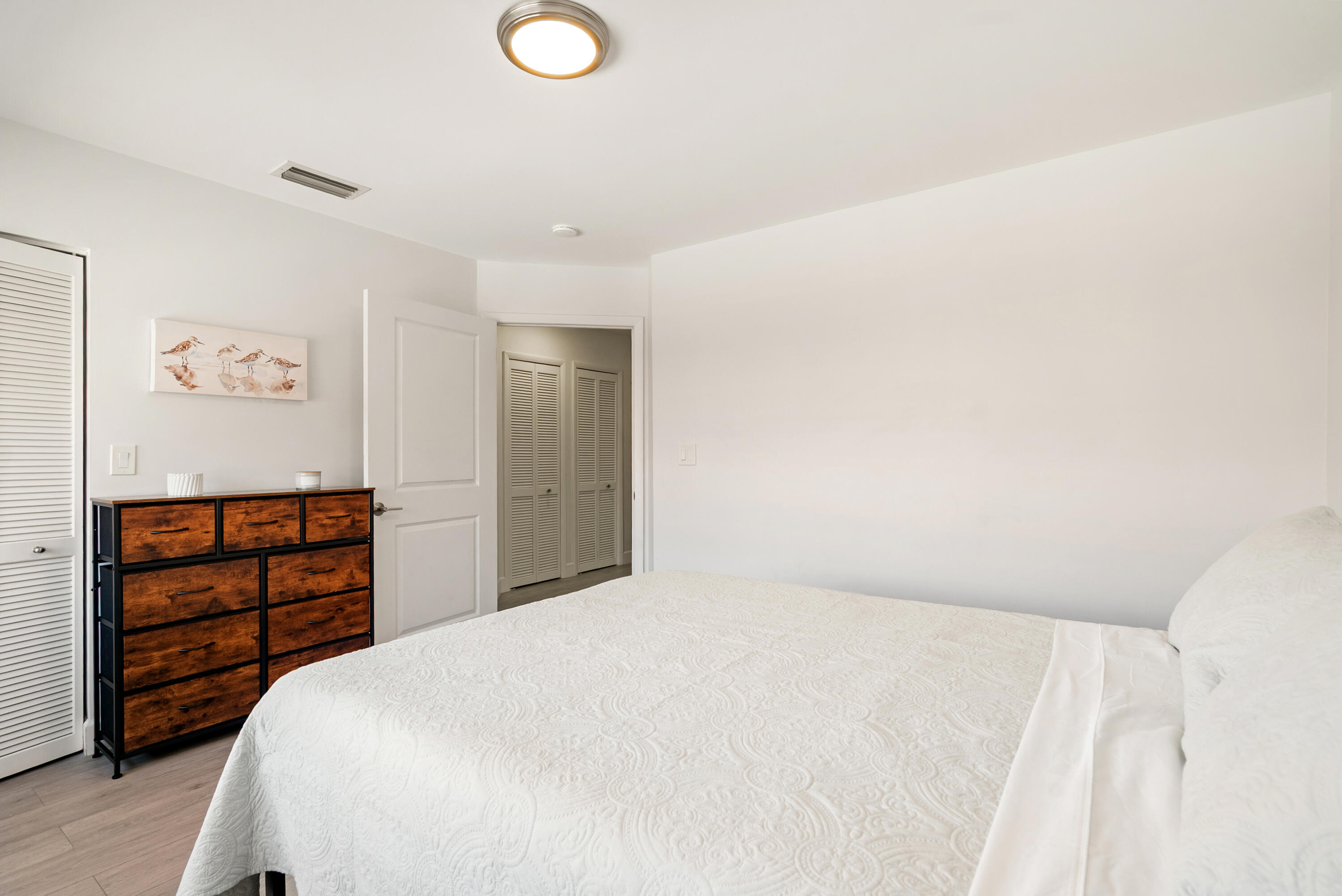 9871 Leeward Avenue Key Largo, FL 33037 - Photo 16 of 38 a bedroom with a bed and cabinets
