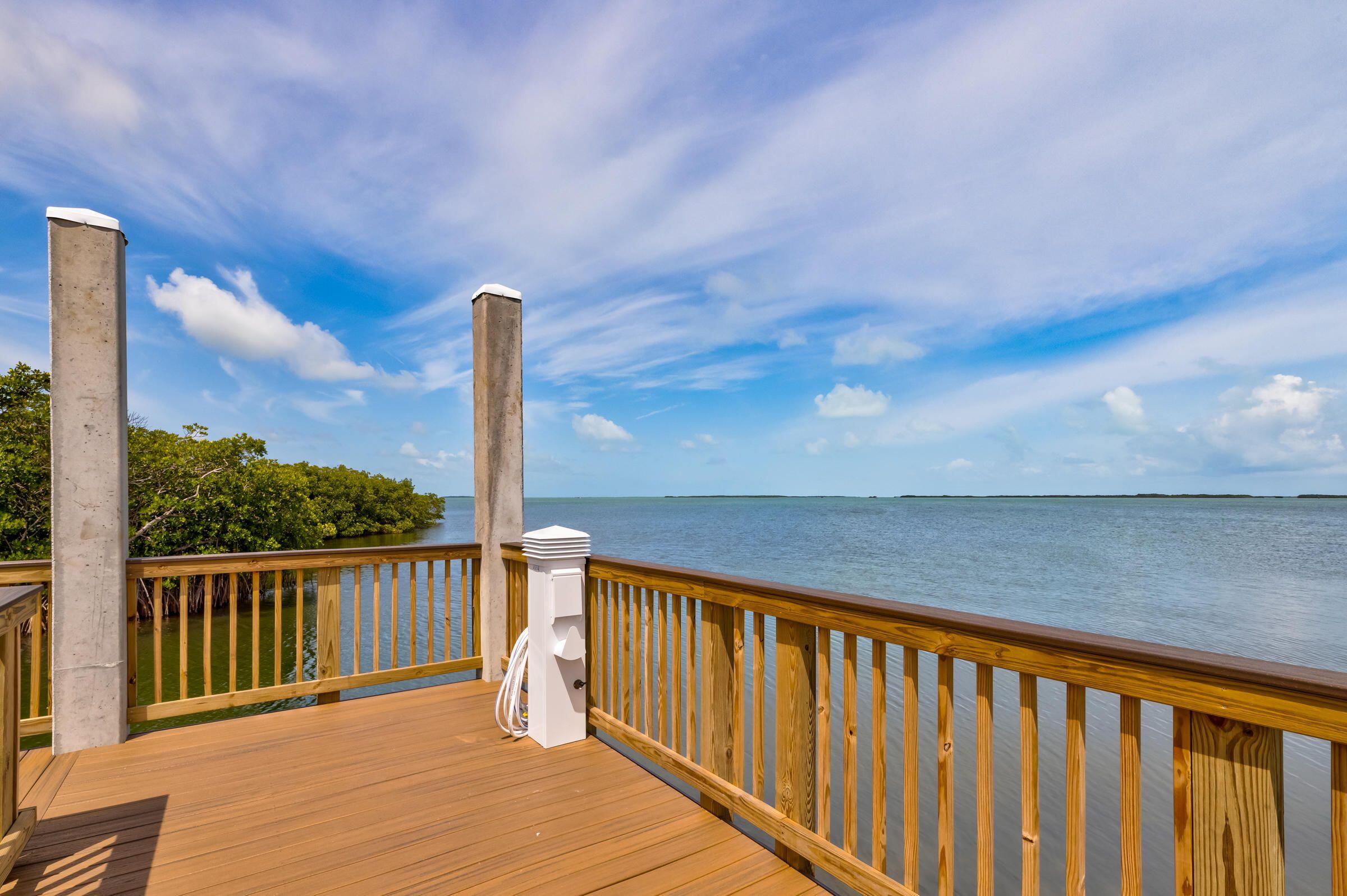 9871 Leeward Avenue Key Largo, FL 33037 - Photo 34 of 38 a balcony with wooden floor and fence