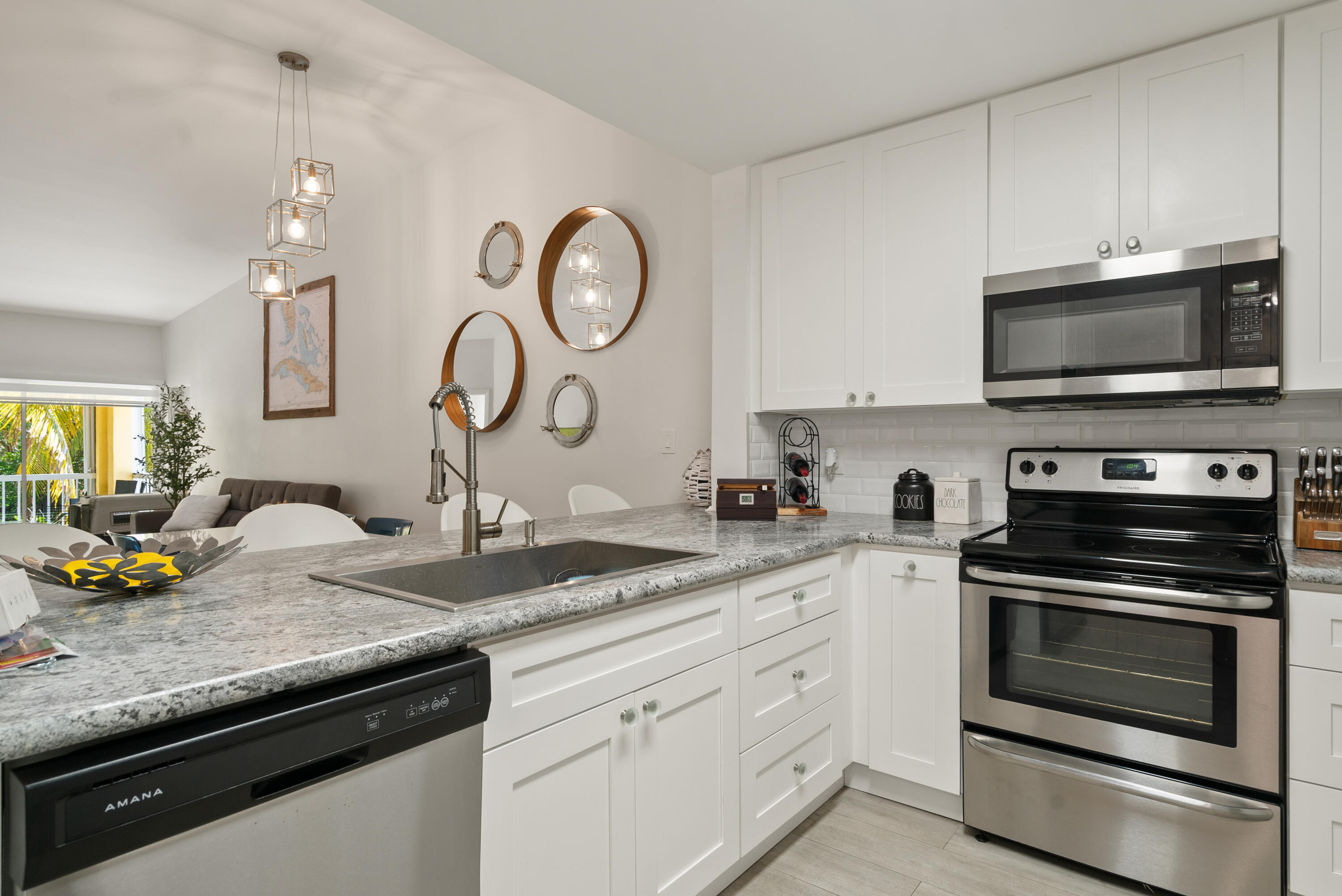 9871 Leeward Avenue Key Largo, FL 33037 - Photo 8 of 38 a kitchen with granite countertop white cabinets and stainless steel appliances