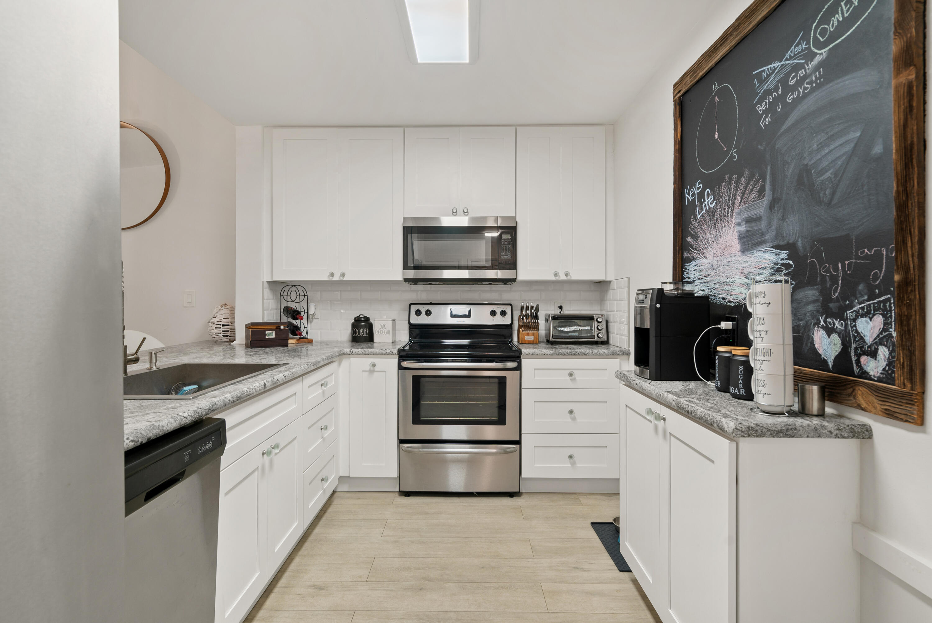 9871 Leeward Avenue Key Largo, FL 33037 - Photo 9 of 38 a kitchen with white cabinets and appliances