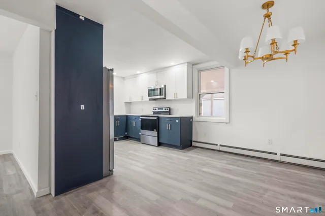 a view of a kitchen with a sink and dishwasher cabinet with wooden floor