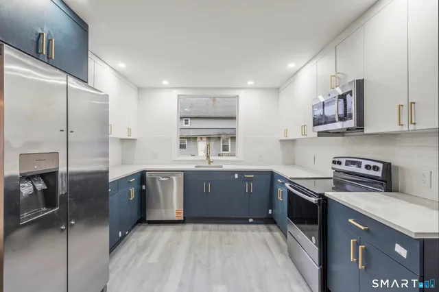 a kitchen with stainless steel appliances granite countertop a sink stove and refrigerator