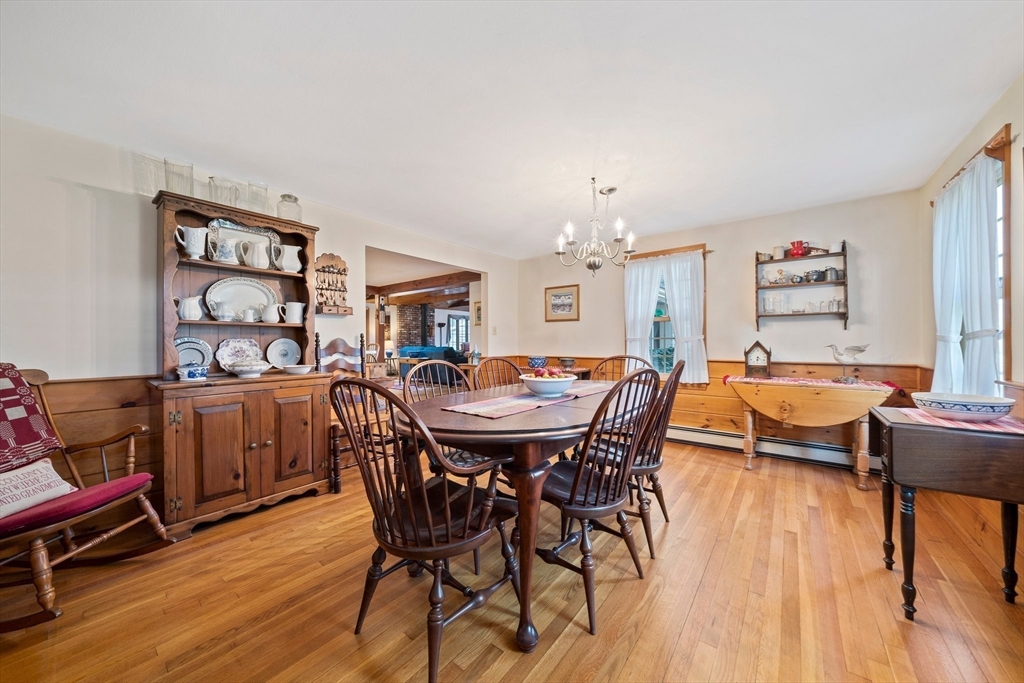 95 Wapping Road Kingston, MA 02364 - Photo 12 of 42 a dining room with wooden floor a chandelier a wooden table and chairs
