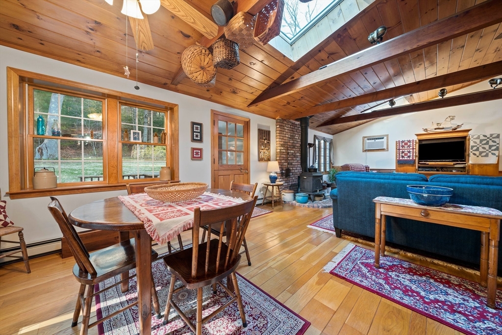 95 Wapping Road Kingston, MA 02364 - Photo 9 of 42 a view of a dining room with furniture a fireplace and wooden floor