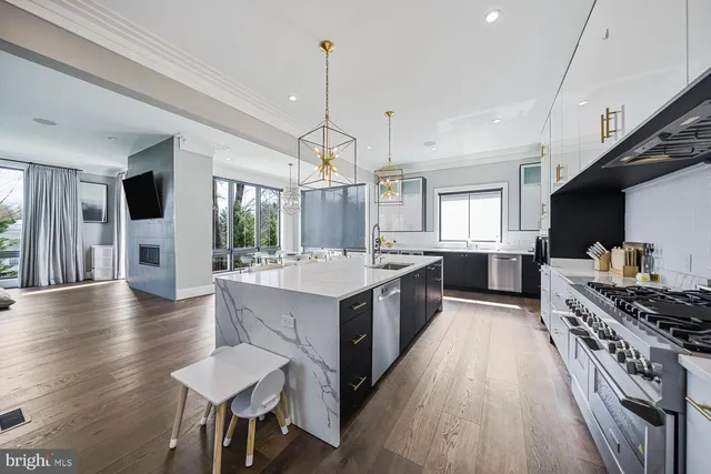 a large white kitchen with lots of counter space a sink and appliances