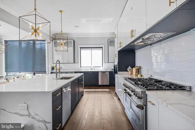 a kitchen with stainless steel appliances kitchen island granite countertop a table chairs and a view of living room