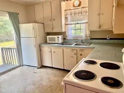 a kitchen with granite countertop white cabinets and white appliances