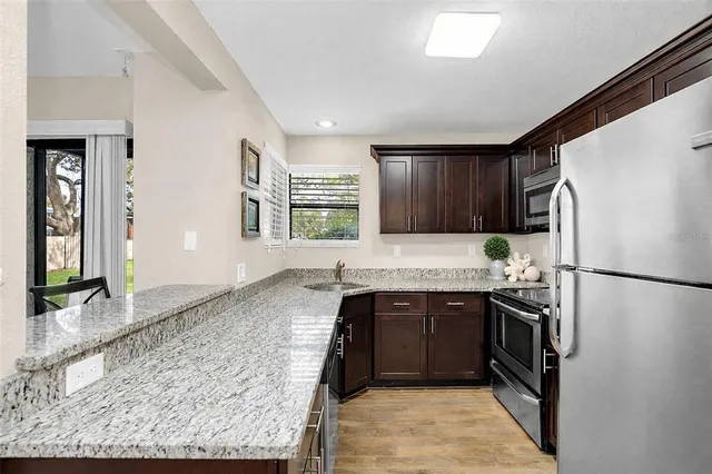 a kitchen with a sink refrigerator and cabinets