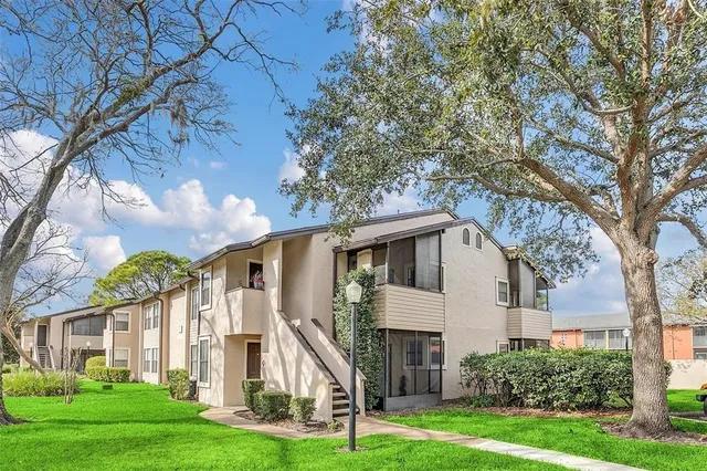 a front view of a house with a yard and trees