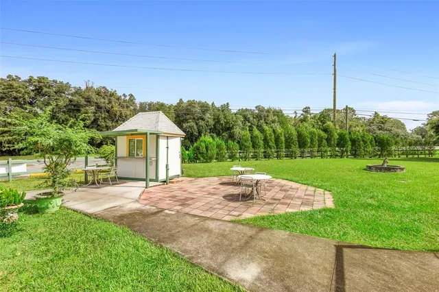 a view of a dining room and livingroom with furniture wooden floor a rug a painting and a chandelier