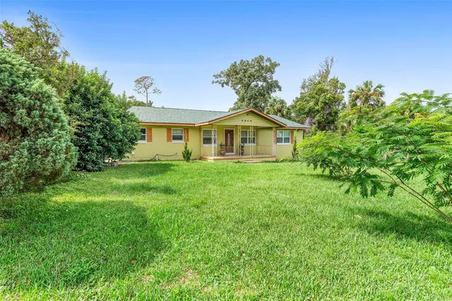 a dining room with wooden floor a chandelier fan a wooden table and chairs