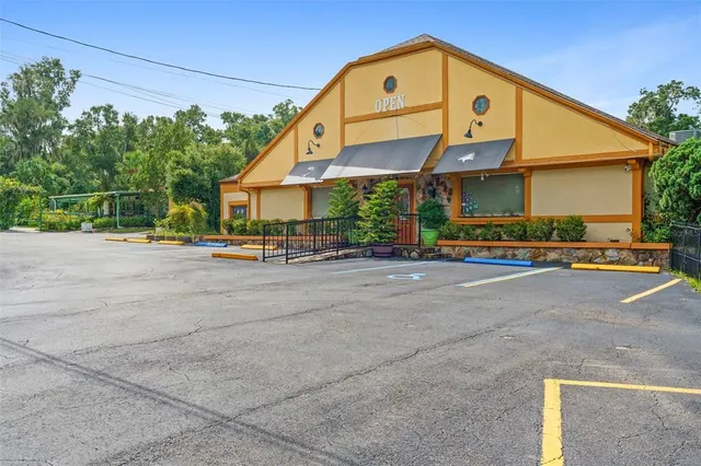 a front view of a house with a yard and potted plants