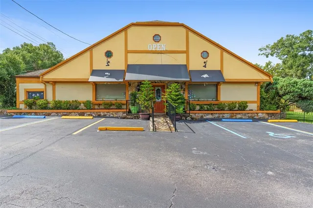 a front view of a house with a yard and potted plants