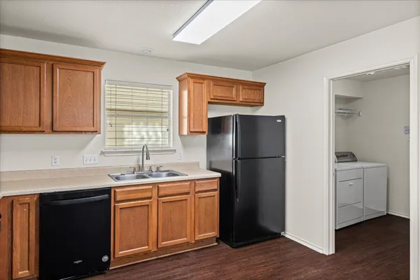 a kitchen with a refrigerator sink and cabinets
